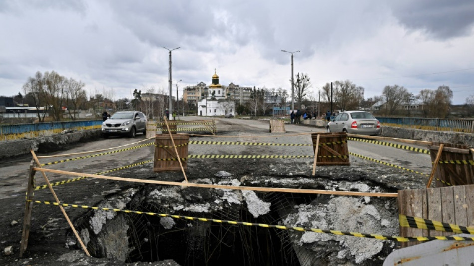 Mother weeps by roadside grave on route of Russian retreat