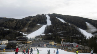 Alpine tourists ski amid brown hillsides